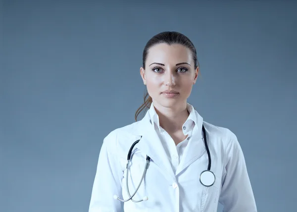 Sexy brunette doctor ready to serve you. Multiuse grey backgroun — Stock Photo, Image
