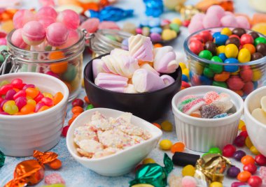 Jöle şekerli sakızlı şekerler mavi masada her çeşit meyankökü ve çilekli şekerlemeler ve çok çeşitli şekerler..