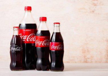 Londra, İngiltere - 03 Ağustos 2018: Ahşap üzerine orijinal Coca Cola meşrubat plastik ve cam şişeler. Dünyanın en popüler içkisi.