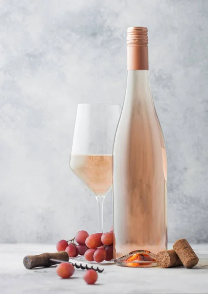 배경에 포도와 코르크 마개가 분홍색 포도주를 유리병 — 스톡 사진