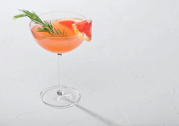 Forfriskende Sommerrød Grapefrugtcocktail Krystalmartini Glas Med Frugtskive Rosmarin Hvid Baggrund - Stock-foto