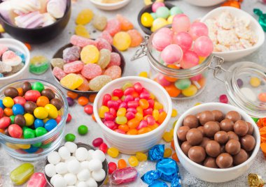 Kavanozda pembe lolipop şekerlemeleri çeşitli sütlü çikolata ve jöleli sakızlı şekerler üzerine beyaz meyankökü ve çilekli şekerler.