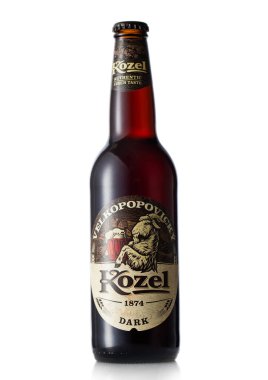 LONDON,UK - JUNE 30, 2022: Kozel dark beer in glass bottle on white. Authentic czech taste.
