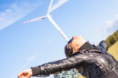 Tuval-pelerin ve windturbine arka planda tutan kız