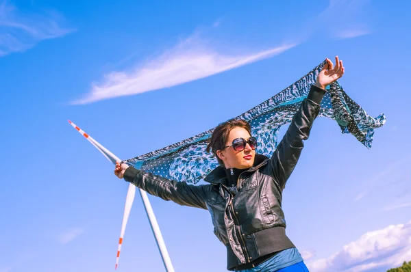 Mädchen mit Leinwand-Umhang und Windturbine im Hintergrund — Stockfoto