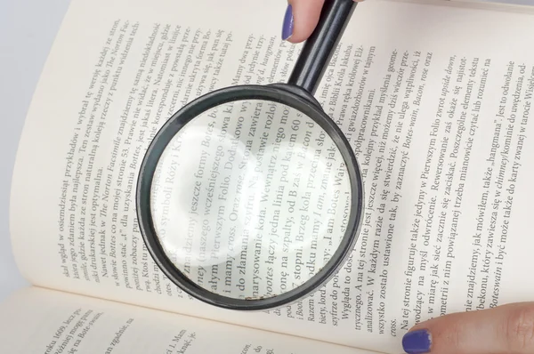 Magnifying glass over book — Stock Photo, Image