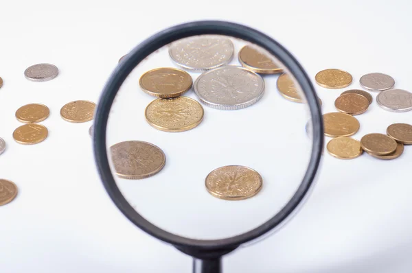 Coins on magnifying glass — Stock Photo, Image