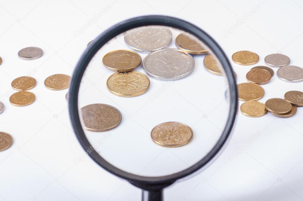 coins on magnifying glass