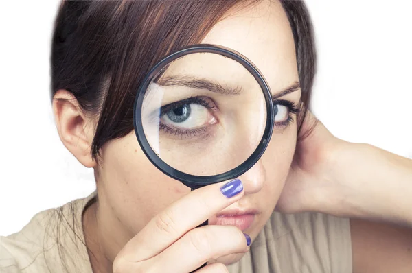 Girl with magnifying glass over her face — Stock Photo, Image