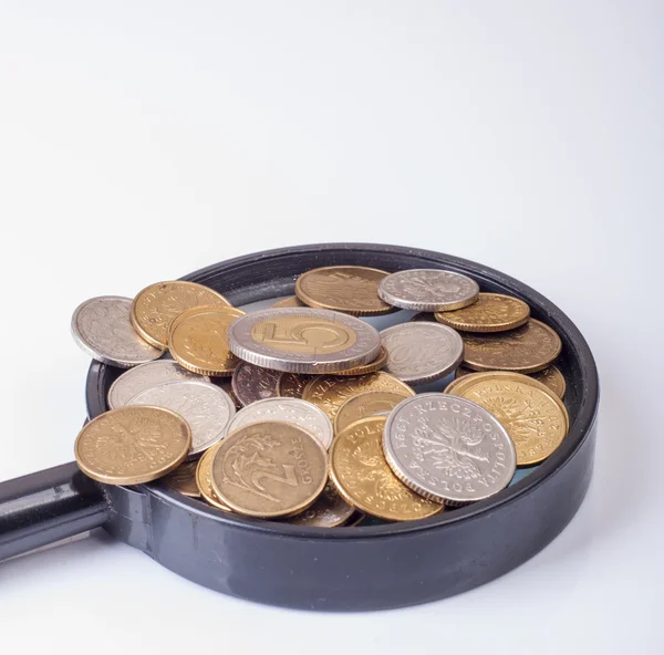 Coins on magnifying glass — Stock Photo, Image