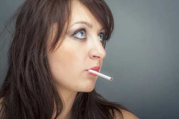Hermosa mujer fuma un cigarrillo — Foto de Stock