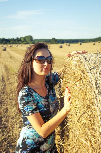 Brunette girl portrait and straw bale — Stock Photo, Image