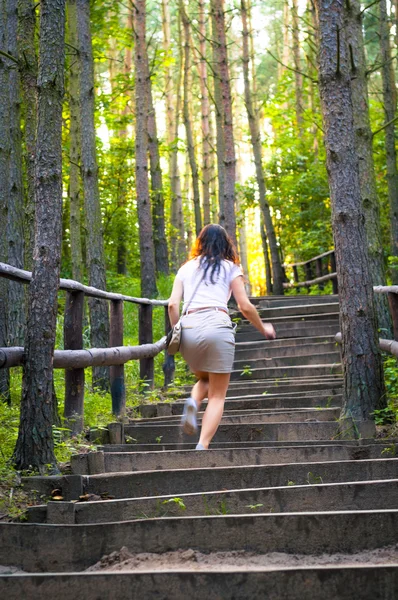 Girl walking through the forest pathway