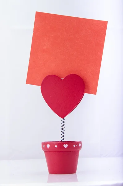 Красный держатель с сердцем и бумагой — стоковое фото