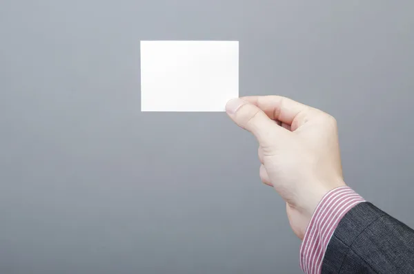 Empresario sosteniendo tarjeta en blanco — Foto de Stock