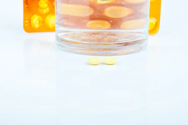 Píldoras y vaso de agua —  Fotos de Stock