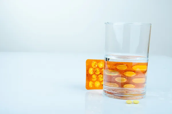 Prášky a sklenice vody — Stock fotografie
