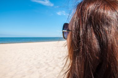 Kumsalda yürüyen turistler