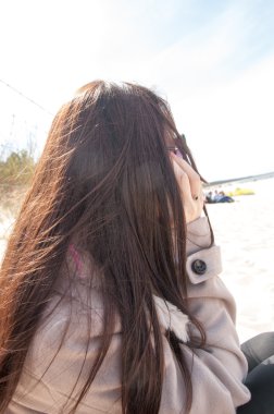 Kumsalda yürüyen turistler