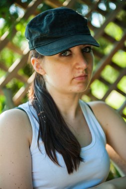 bahçede bir sandalyede oturan genç kız