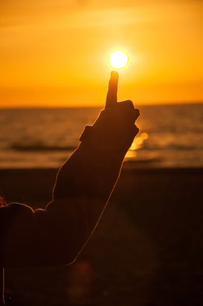 Kvinderne hånd på solnedgang. på stranden - Stock-foto