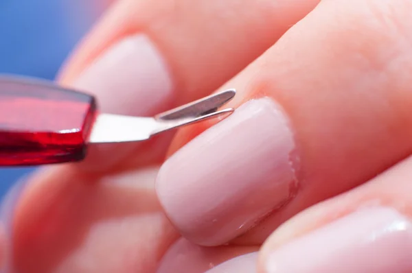 Meisje snijdt de huid op de nagel — Stockfoto