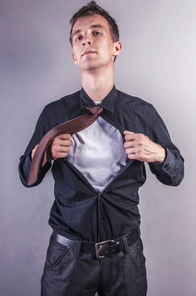 Ung forretningsmand trækker skjorte - Stock-foto