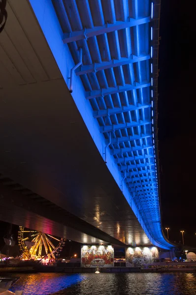 Ponte iluminada à noite pelo rio — Fotografia de Stock