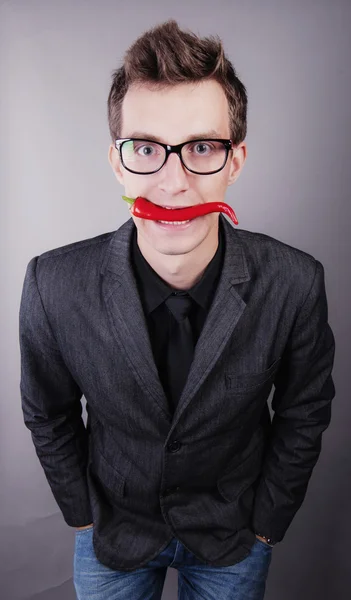 Businessman with chili pepper in the mouth — Stock Photo, Image