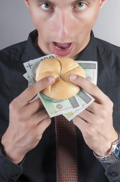 Işadamı para ile bir sandviç yiyor — Stok fotoğraf