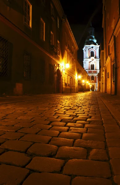 Straat met kerk door nacht in poznan, Polen — Stockfoto