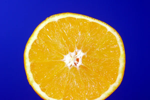 Mavi bir arka plan üzerine portakal kesilmiş — Stok fotoğraf