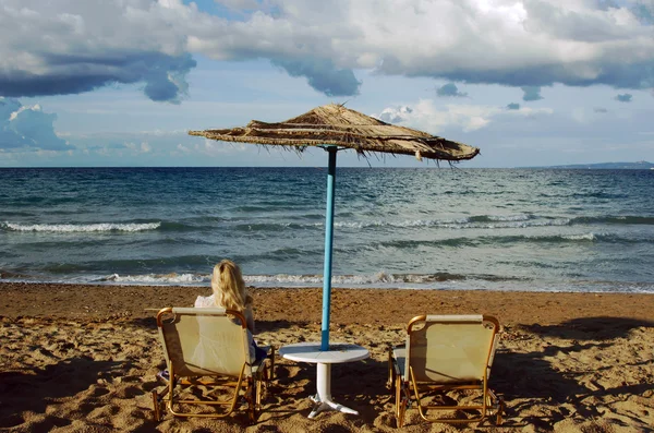 Uma menina e guarda-chuva de praia no mar — Fotografia de Stock