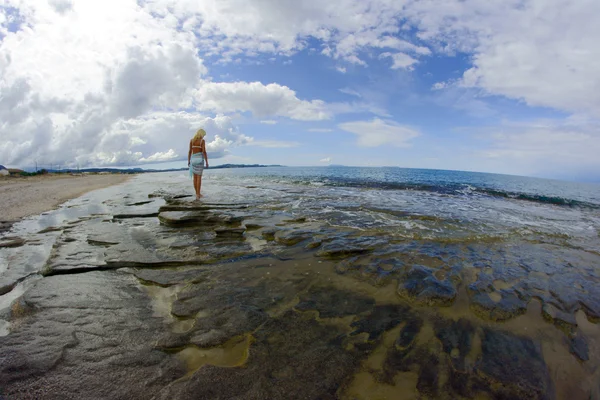 La ragazza su una spiaggia rocciosa — Foto Stock