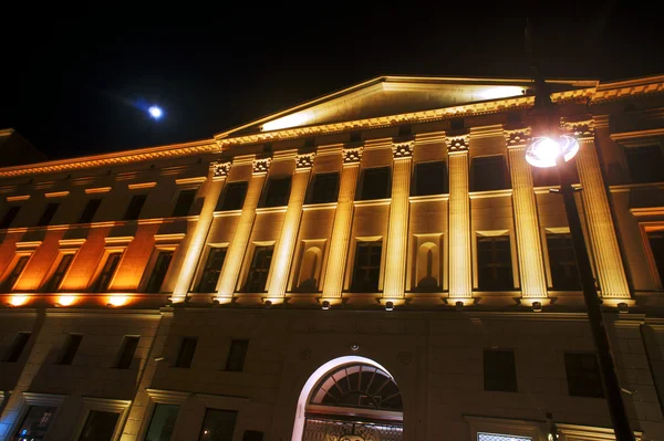 Facciata illuminata dell'edificio e luna — Foto Stock