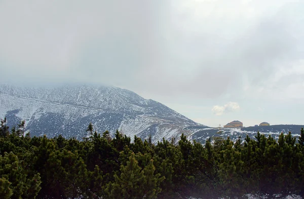 Cubierta de nieve ladera de la montaña y refugio — Foto de Stock