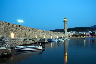 Yunanistan 'ın Girit adasındaki Rethymno limanında tarihi bir taş duvar ve bir deniz feneri