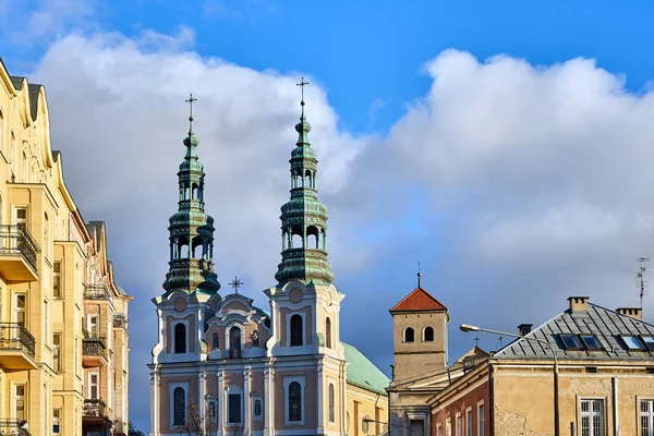 Poznan şehrindeki tarihi apartman evleri ve barok bir kilisenin çan kuleleri.