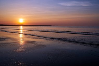 Polonya 'da akşam vakti Baltık Denizi' nde kumlu bir plajda gün batımı