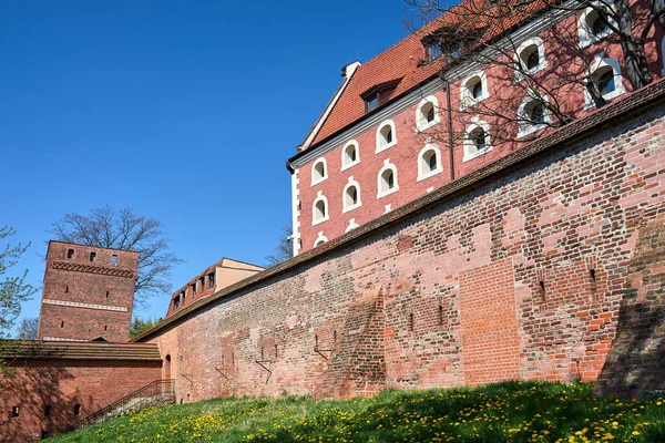 a historic defensive wall with a brick tower in the city of Torun in Poland