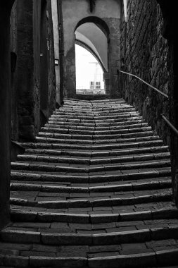 Dik, asfaltlı bir sokak merdivenleri ve İtalya 'daki Sahip Maritima şehrinde taş bir kapı, tek renkli.