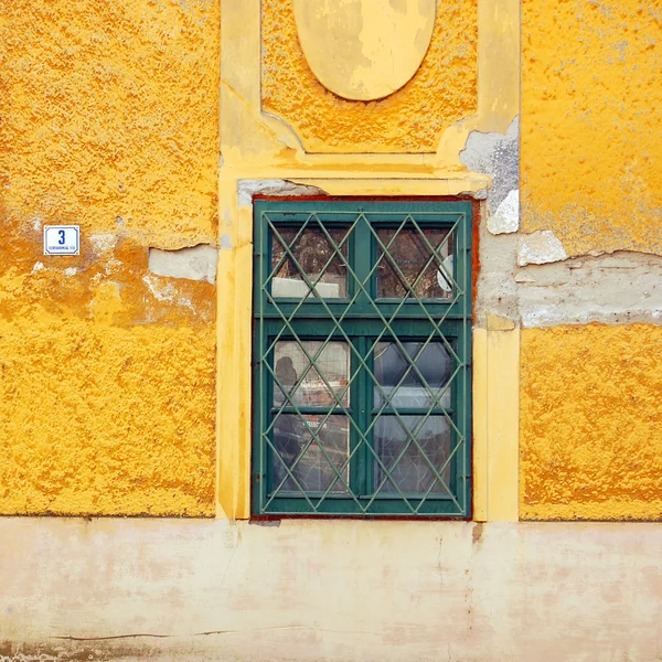 Detalhe do edifício amarelo com janela verde — Fotografia de Stock