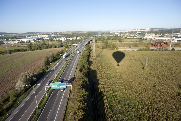 Letecký pohled na dálnici uprostřed polí, luk a město — Stock fotografie