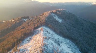 Aerial camera rises above winter mountains