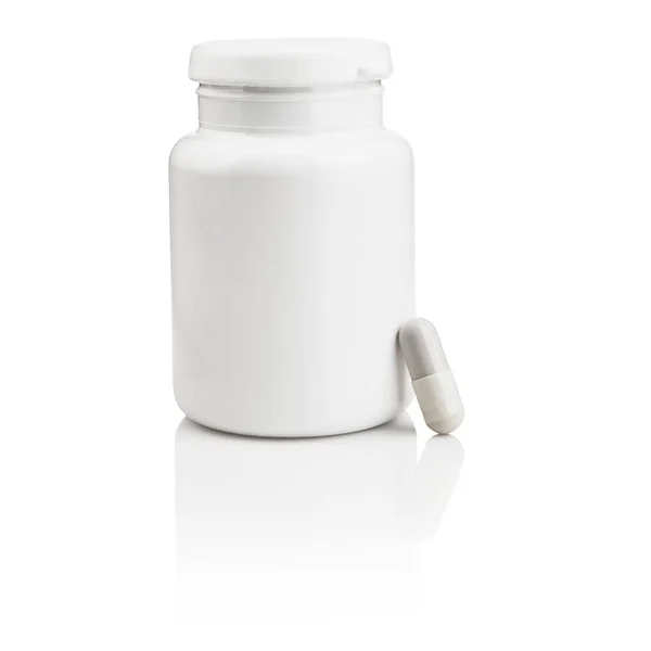 塑料药瓶和一个在白色背景上隔离的胶囊 带有倒影 — 图库照片