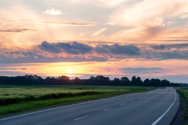Huysuz, güzel bir gün batımı ve bir yol. Seyahat kavramı