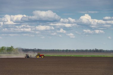 Kırmızı Ukrayna traktörü tarlada. Ukrayna 'da tarım endüstrisi. Yiyecek tedarik krizi illüstrasyonu. Kırsal alan