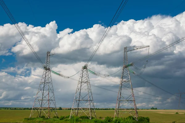 Wysokonapięciowe Słupy Linii Energetycznej Przeciwko Błękitnemu Niebu Chmurami Dostawy Dystrybucja — Zdjęcie stockowe