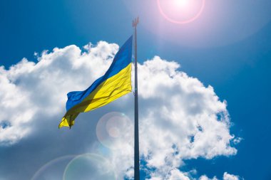 Ukrayna ulusal bayrağı direğin üzerinde, mavi gökyüzünde bulutlu mızrak var..