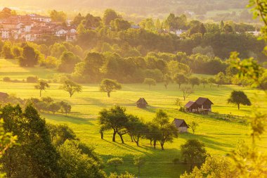 Slovenya 'nın Soca Vadisi' ndeki manzara kırsalında. Yeşil çayırlar ve otlaklarla güzel gün batımı tepeleri